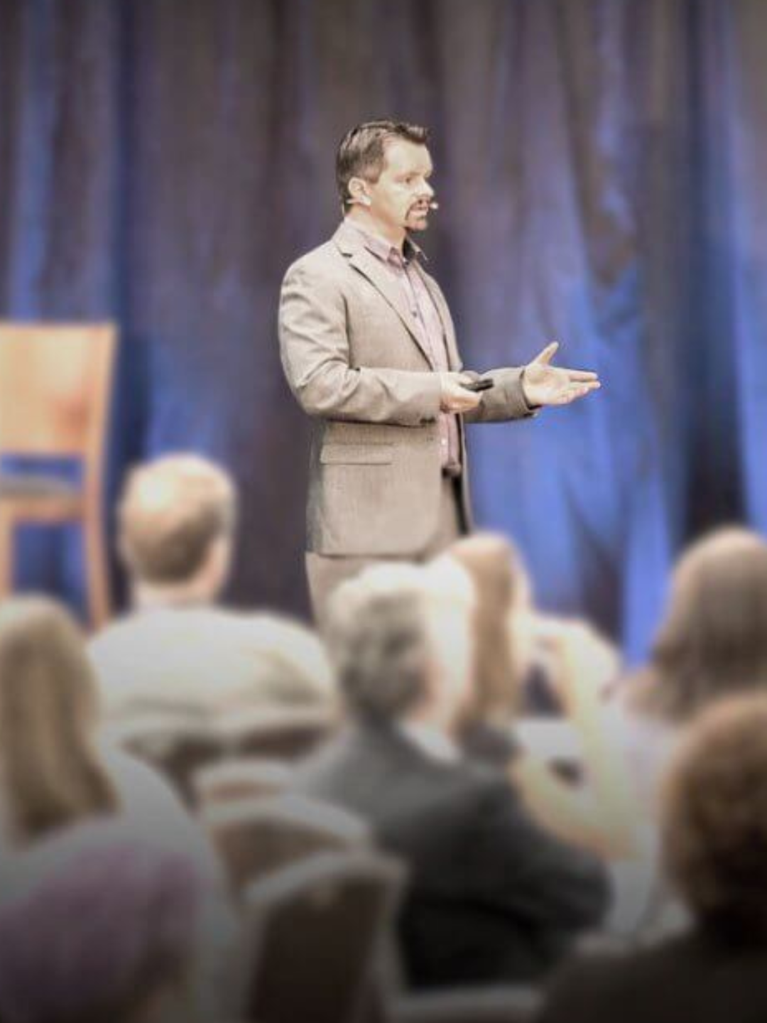 Greg Cassar presenting on stage to an audience at a marketing event.